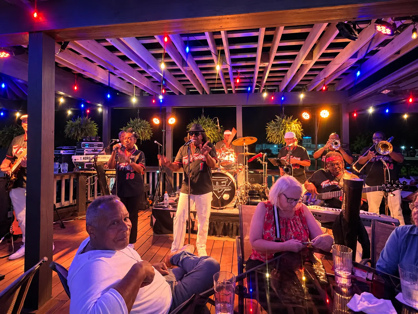 A live band performing under the patio lights at The Coachman