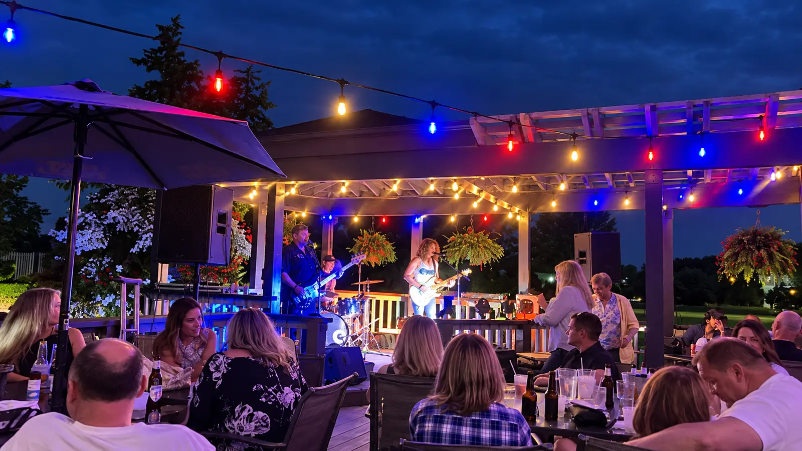 Guests enjoying a nighttime band performance on The Coachman patio